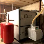 Industrijski bojler sa crvenim rezervoarima u prostoriji.